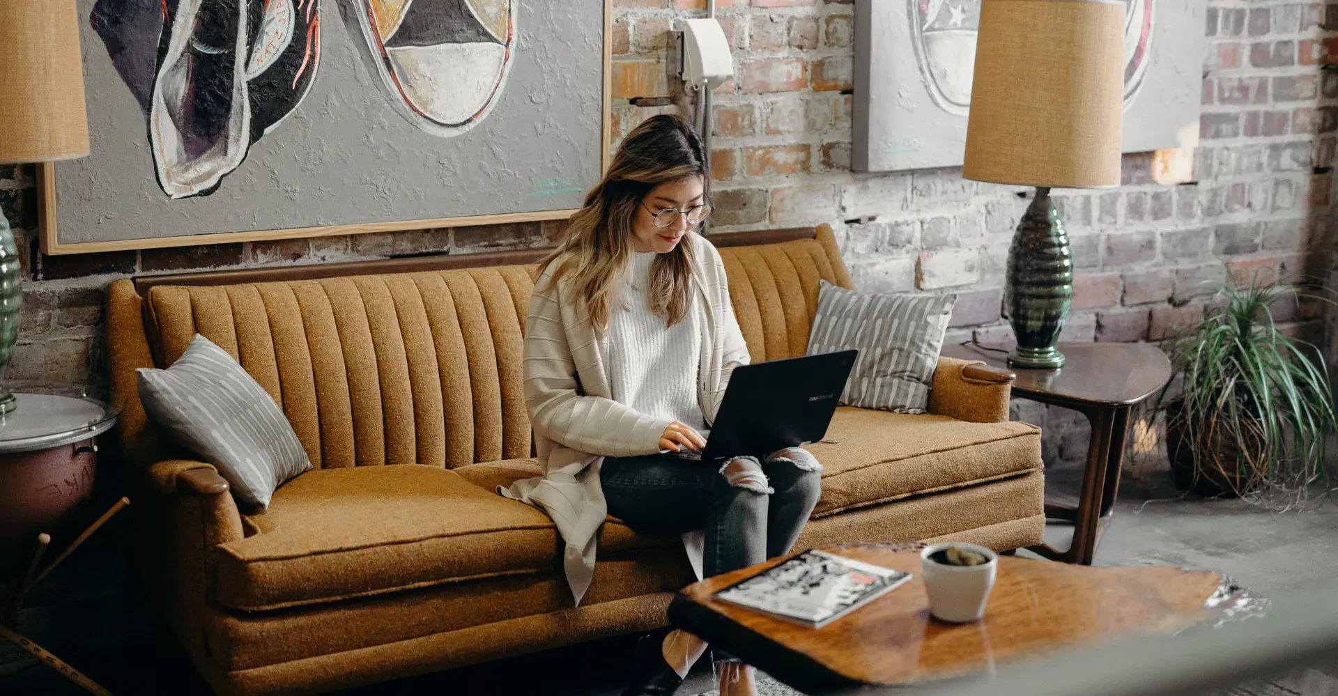 woman on a laptop sitting on her couch